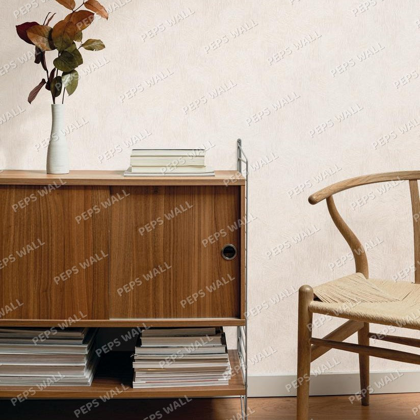 Beige textured wallpaper shown in a styled interior scene with a wooden cabinet, books, a vase with dried leaves, and part of a wooden chair.
