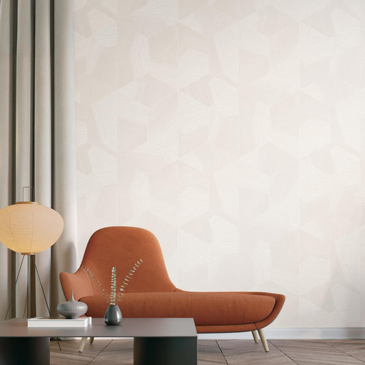 A modern interior scene featuring a large wall with a light beige and white geometric pattern, styled with an orange-brown lounge chair, a low dark coffee table, a paper lantern lamp, and minimalist vases.