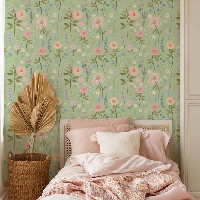 Wallpaper Kids Nursery Dubai A bedroom with floral wallpaper in green, pink, and blue colors, featuring a bed with pink bedding, a wicker basket, and a decorative plant.