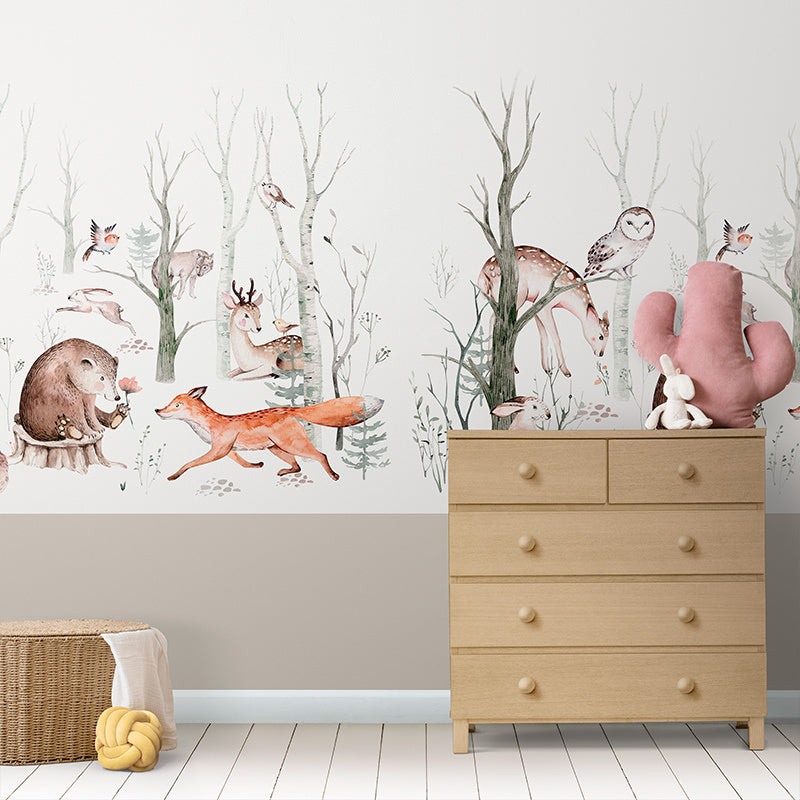 Wallpaper Kids Nursery Dubai A wall featuring wallpaper with a forest animals pattern, including illustrations of deer, foxes, and birds among trees. A wooden dresser and a pink chair are also visible in the room.