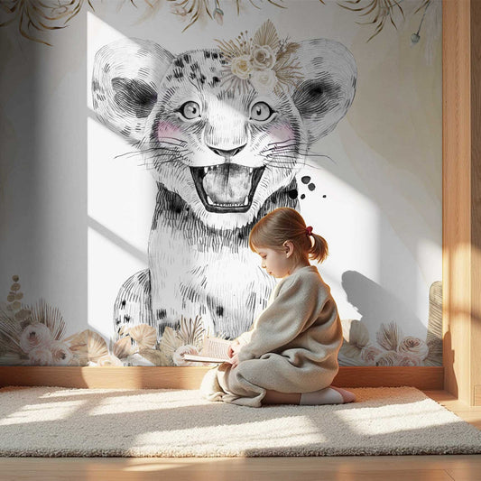Wallpaper Kids Nursery Dubai A child sitting on the floor in a room with a wall paper featuring a cheerful lion's face with floral elements in the background.