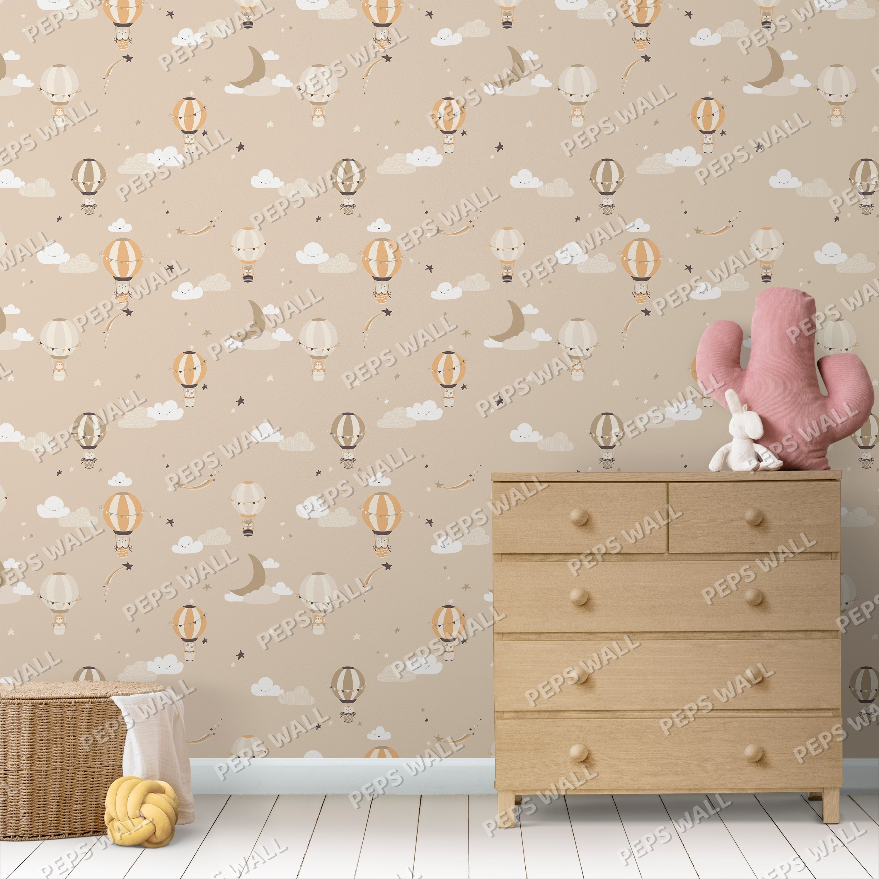Wallpaper Kids Nursery Dubai Peps Wall A room with wallpaper featuring various cartoonish designs including balloons, clouds, and cacti, with a wooden dresser and a pink cactus toy in the foreground.