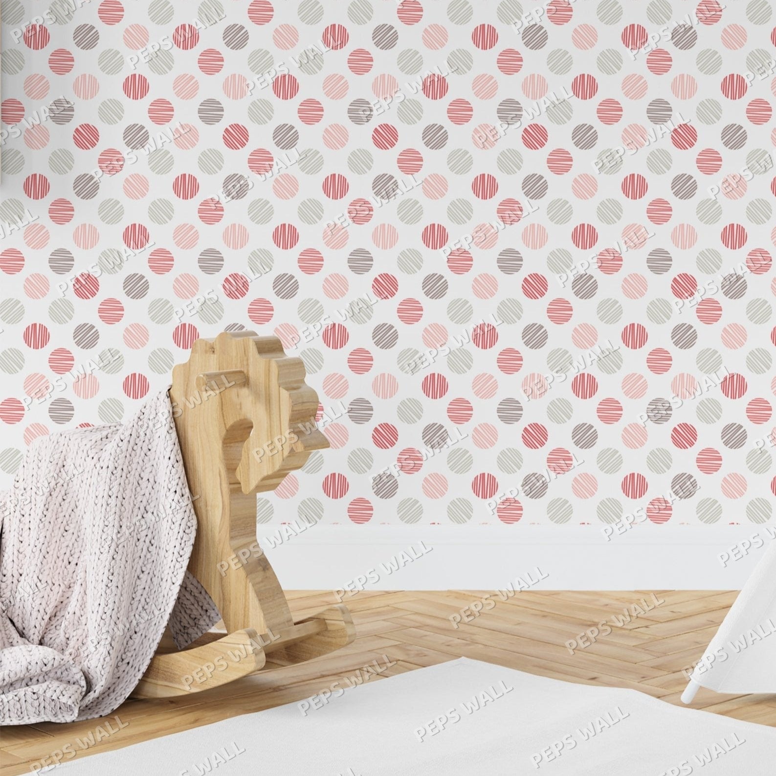 Wallpaper Kids Nursery Dubai Peps Wall A room with wallpaper featuring a pattern of pink and white spherical shapes, and a wooden rocking chair with a white textured fabric sling in the foreground.