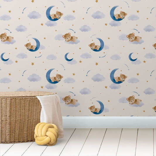 Wallpaper Kids Nursery Dubai Peps Wall Children's room wallpaper featuring a pattern with teddy bears, moons, and stars against a blue and beige background, with a wicker basket and a yellow object on the floor.