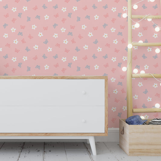 Wallpaper Kids Nursery Dubai Peps Wall A room with pink walls decorated with a floral and butterfly pattern, featuring a white wooden cabinet with four drawers, placed against a backdrop of hanging lights and a decorative ladder.