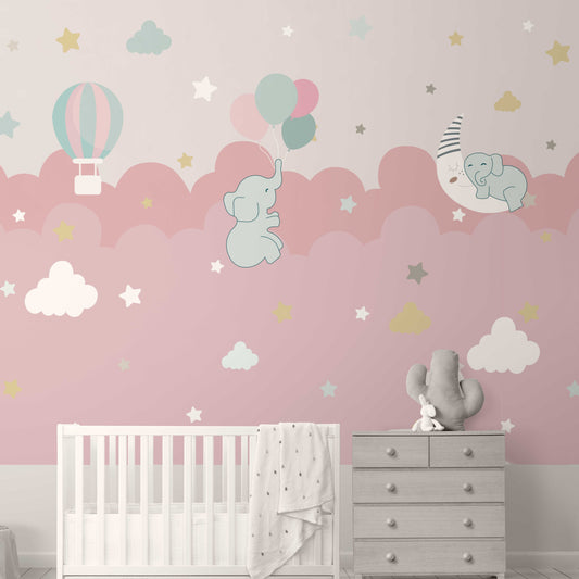 Wallpaper Kids Nursery Dubai Peps Wall Children's room with pink wallpaper featuring clouds, elephants, a moon, and balloons. A crib and a dresser are placed against the wall.