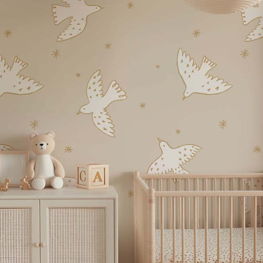 Wallpaper Kids Nursery Dubai Peps Wall A nursery room with beige walls decorated with white and beige bird-shaped wallpaper decals. A teddy bear and a wooden block set are on a shelf, and a crib is visible in the background.
