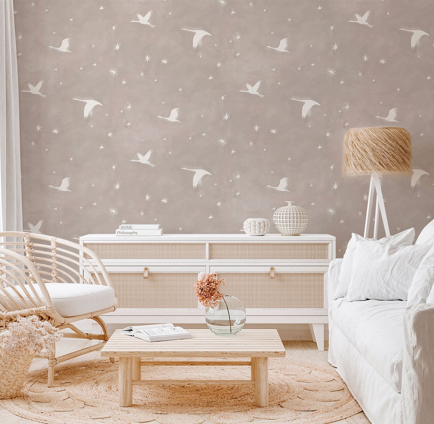 Wallpaper Kids Nursery Dubai Peps Wall A room with beige wallpaper featuring a pattern of white birds in flight. The room is furnished with a white sofa, a wooden coffee table, and a white sideboard.