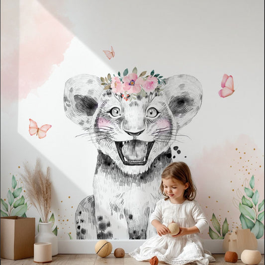 Wallpaper Kids Nursery Dubai Peps Wall A decorative wallpaper featuring a black and white illustration of a lion with pink and white flowers on its head, with butterflies around it, applied on a wall with a child sitting in front of it.