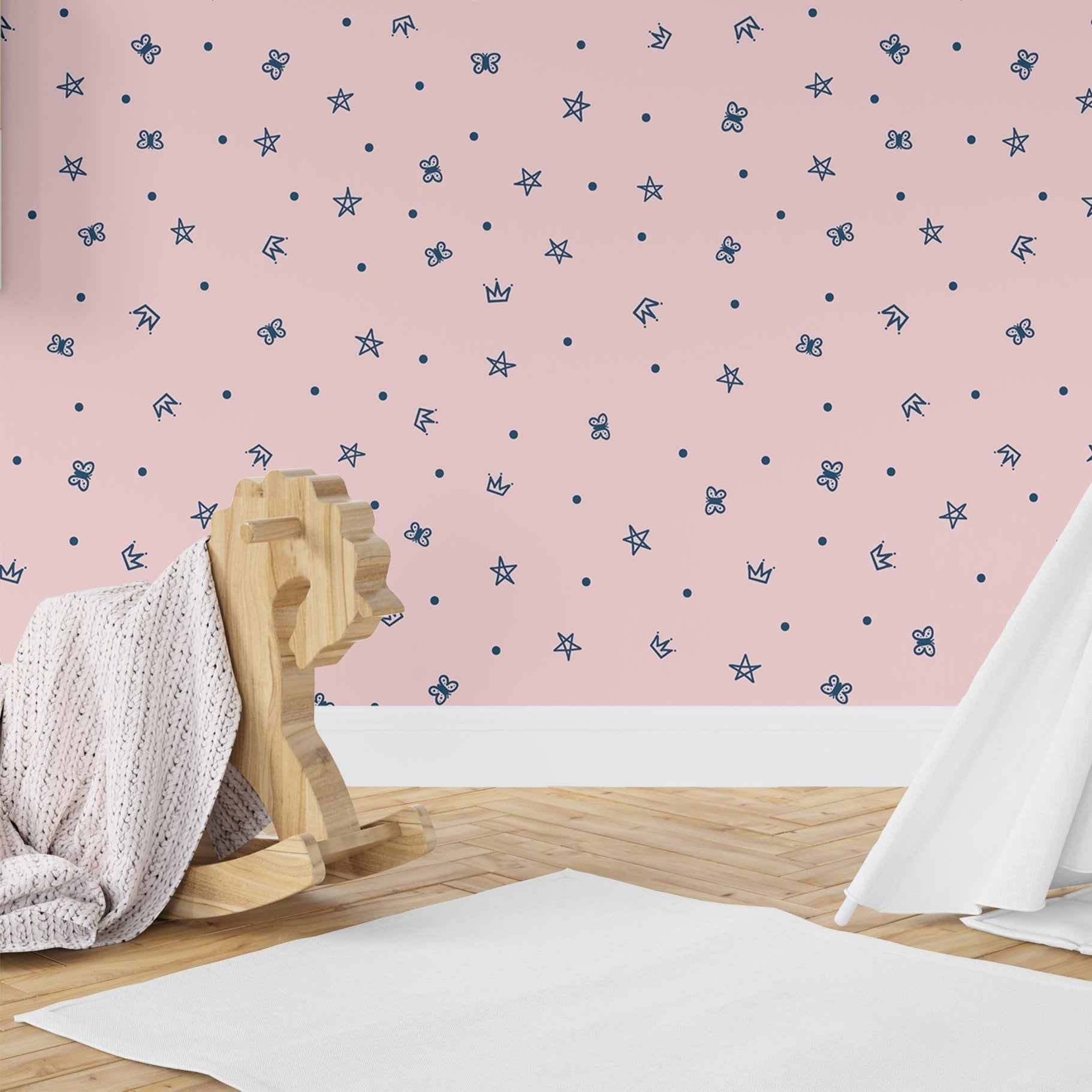 Wallpaper Kids Nursery Dubai Peps Wall A room with a pink wall decorated with a pattern of small blue and white butterflies and stars, featuring a wooden rocking horse and a white blanket.