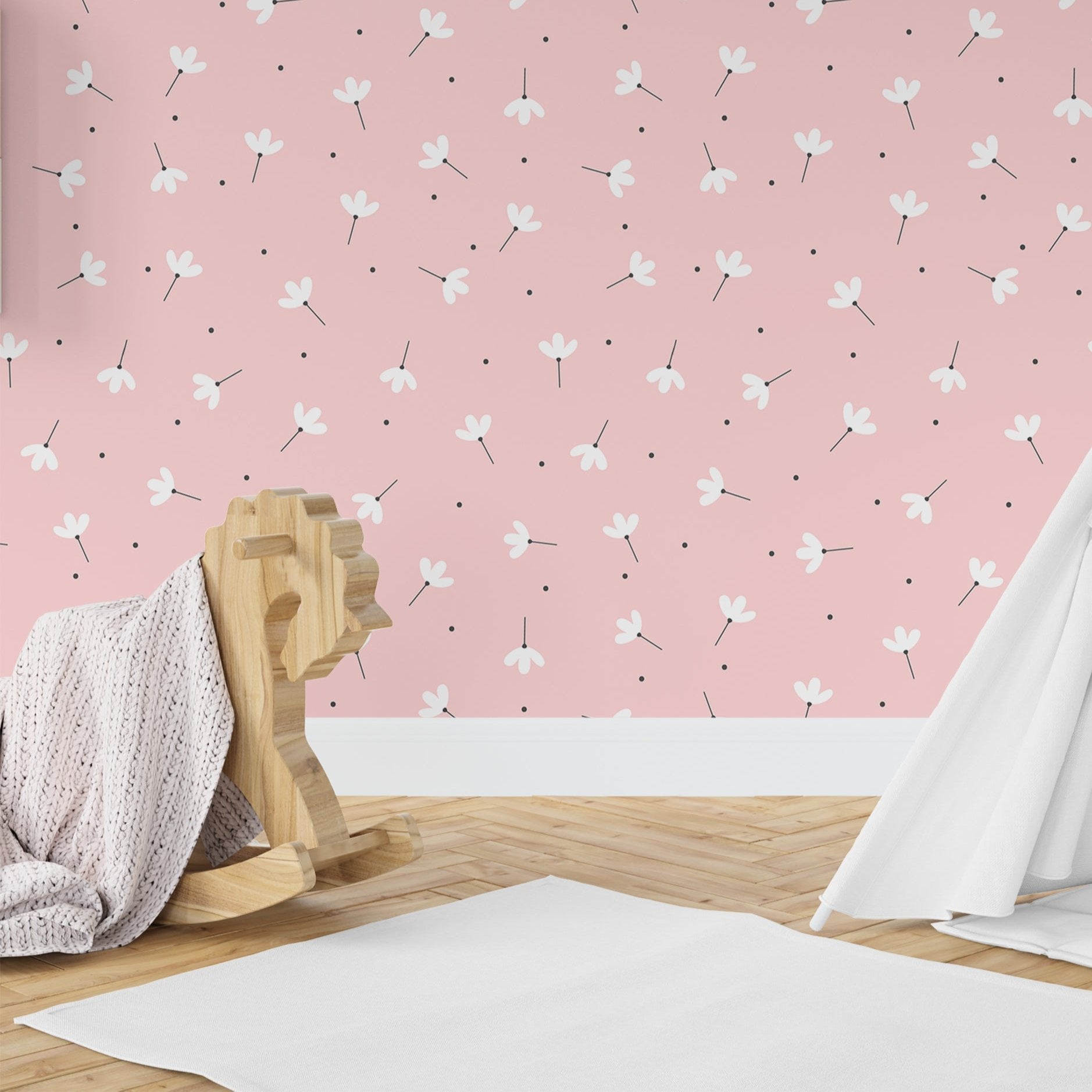 Wallpaper Kids Nursery Dubai Peps Wall A room with pink walls featuring a floral pattern, including a wooden stool and a white blanket, with a partial view of a white curtain.
