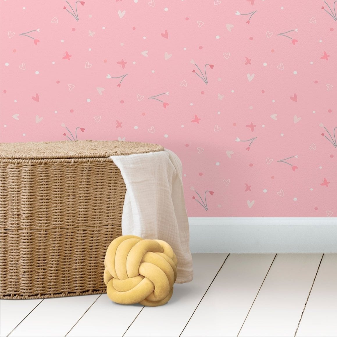 Wallpaper Kids Nursery Dubai Peps Wall A roll of pink wallpaper with a floral and star pattern, placed on a wicker basket against a pink-colored wall.