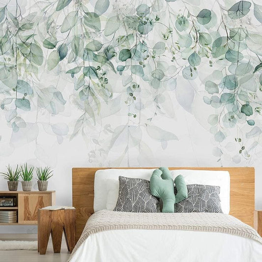 Wallpaper Kids Nursery Dubai Peps Wall A bedroom with a wall adorned with a floral wall mural featuring green leaves and white flowers, with a bed in the center, wooden bedside tables, and a green plant on the floor.