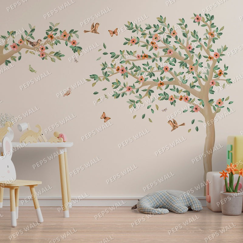 Wallpaper Kids Nursery Dubai Peps Wall A wall decal of a spring tree with branches, leaves, and flowers, placed in a room with children's furniture and decor.