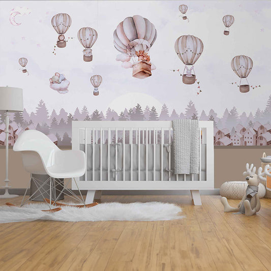 Wallpaper Kids Nursery Dubai Peps Wall A room with a white crib and a chair with a grey balloon-shaped cushion, decorated with wallpaper featuring hot air balloons and a forest scenery.