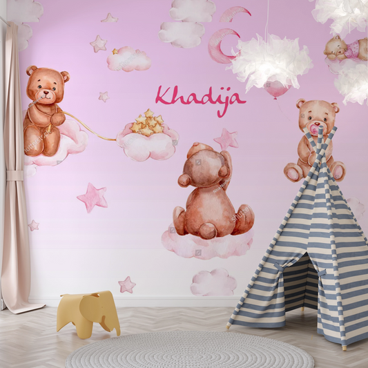 Wallpaper Kids Nursery Dubai Peps Wall A wallpaper featuring cartoon-style teddy bears with a pink background, clouds, and the name 'Khadija' written on it. Part of a children's room decor.