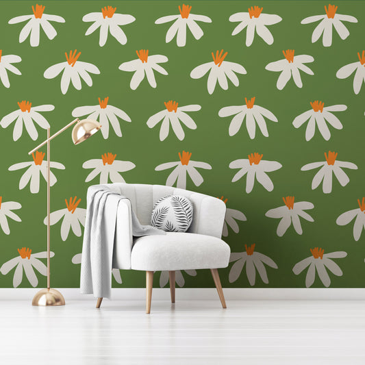 Wallpaper Kids Nursery Dubai A room with green walls covered in a floral pattern with white and orange flowers. There is a white armchair in the room with a gray cushion on it, and a floor lamp with a beige lampshade is also visible.