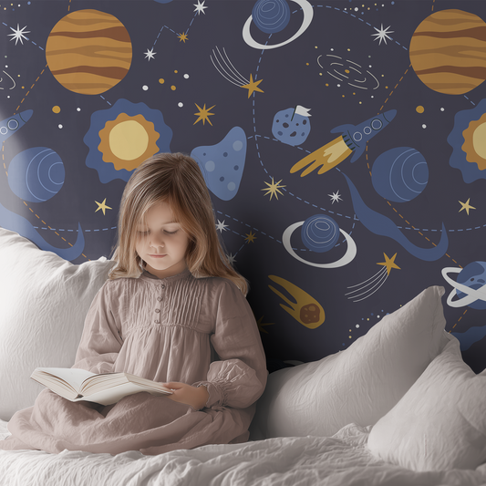 Young girl reading a book in a room with truck-themed wallpaper