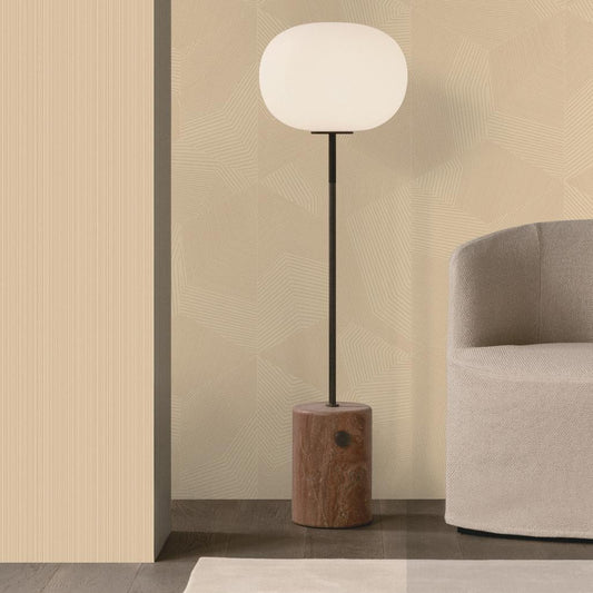 A modern floor lamp with a glowing white oval shade, a slim black stem, and a cylindrical wooden base, styled in a minimalist interior next to a light gray armchair.